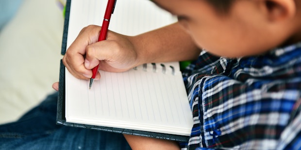 Child writing nature journaling